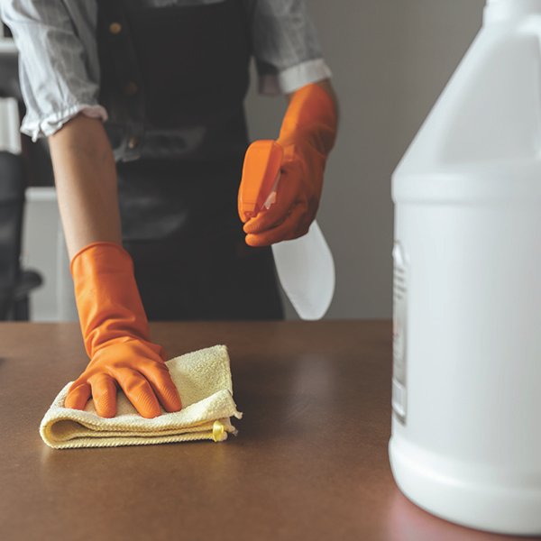 worker-cleaning-table-with-cleaning-solution Restaurant worker using cleaning solution to clean tables.